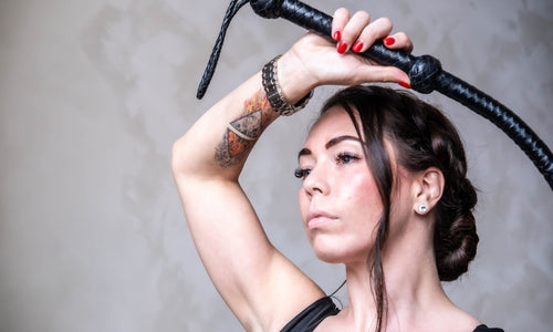 Frau hält BDSM Peitschen in Hand