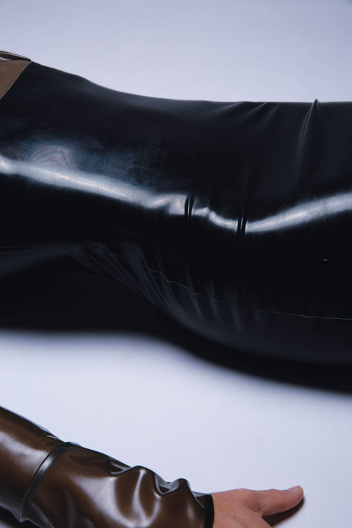 Frau mit Frau mit Latex-Bodysuit liegt auf Boden